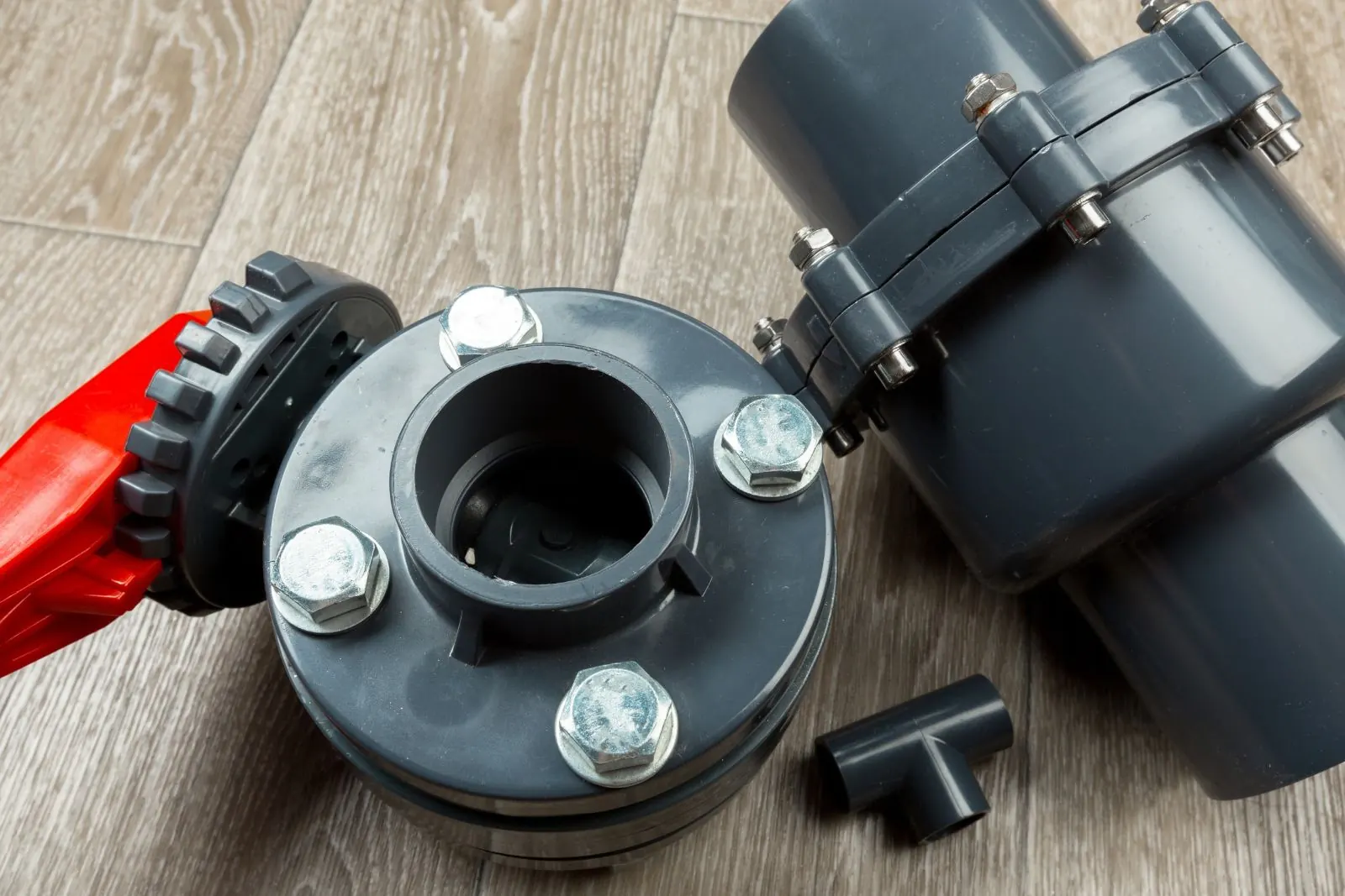 Gray PVC union and drain fittings laid out for a sink drain connection