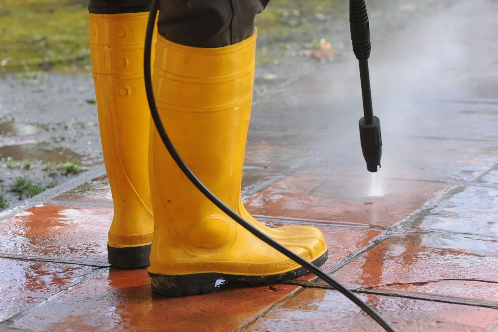 High-pressure water jet blasting grime off wet pavement