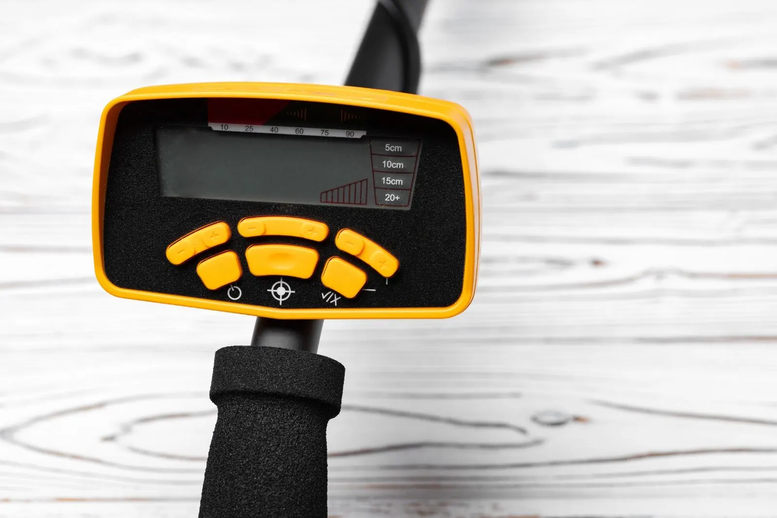 Handheld electronic detector held over a wood floor